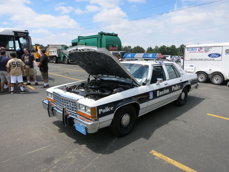 White and black Boston Police sedan with open hood at show