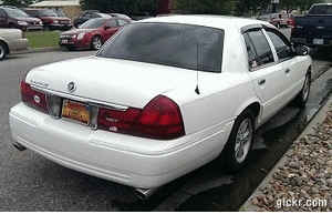 2000 Mercury Grand Marquis - White 2000 Mercury Grand Marquis sedan parked curbside, showing its rear and side profile.