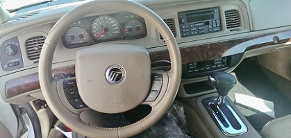 2000 Mercury Grand Marquis - The interior of a 2000 Mercury Grand Marquis is visible, including the steering wheel and dashboard.