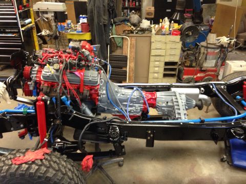 1993 Ford Bronco - The engine and transmission are mounted onto the vehicle's chassis in a workshop.