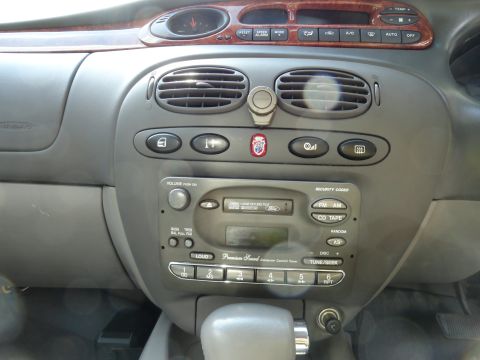 1999 Ford Fairlane - Close-up of a car's dashboard, showing the center console with audio controls and air vents.