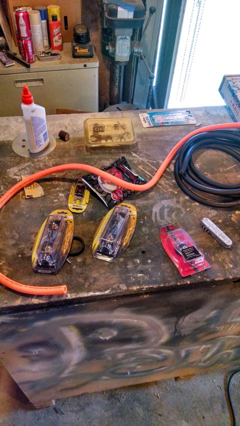 1995 Ford Bronco - A workbench is cluttered with various tools, including a drill press, hoses, and packaged lighting components.