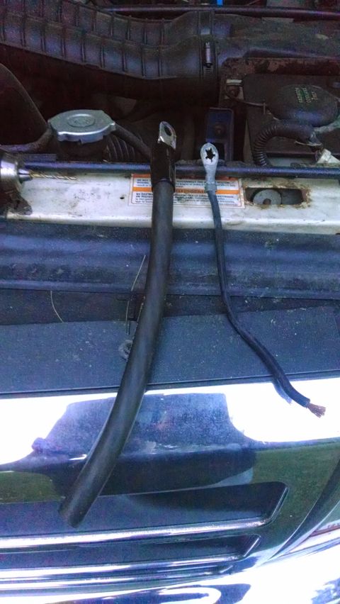 1995 Ford Bronco - Two battery cables are visible in the engine bay, one thick and one thin.