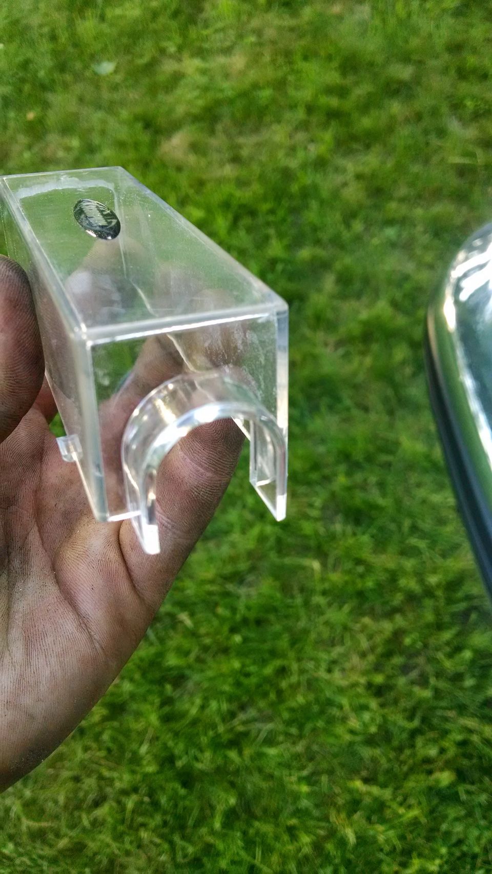hand holding clear plastic part with a U-shaped cutout