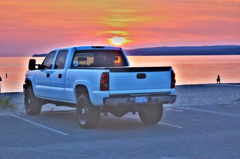 2006 Chevrolet Silverado 2500 - Rear view of a white 2006 Chevrolet Silverado 2500 parked by the water during sunset.