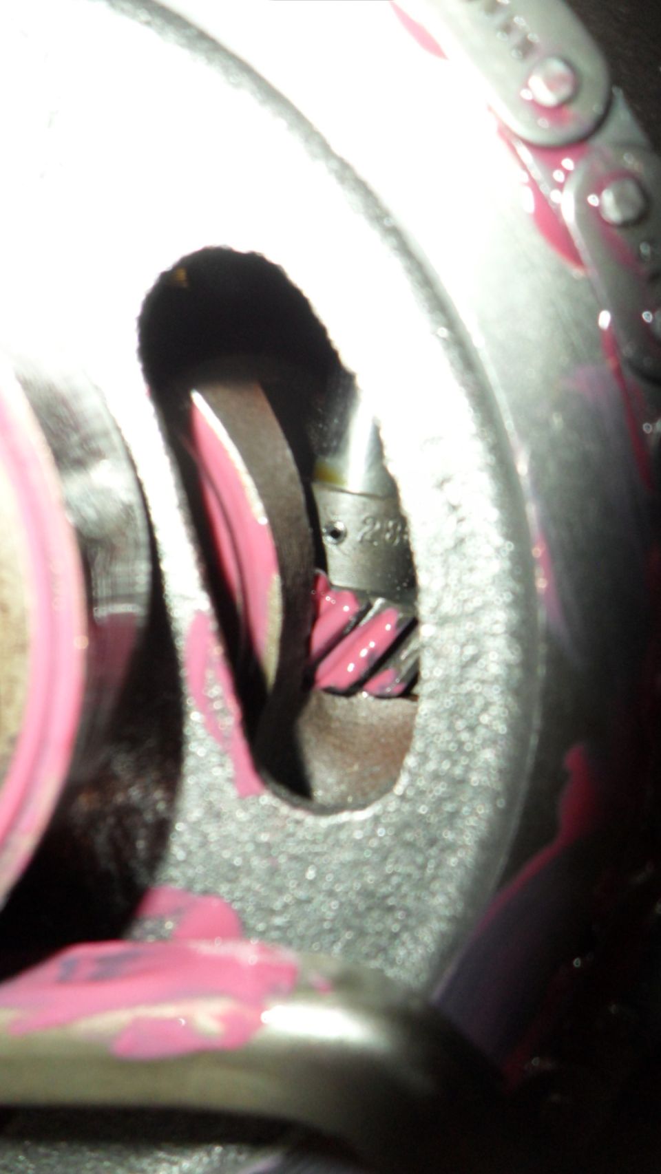 Close-up of engine timing chain and gears with pink lubricant