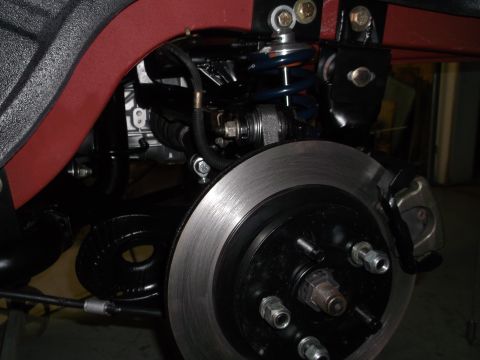 1967 Ford Mustang - This image shows a close-up of a vehicle's rear suspension and brake system, including the coil spring and shock absorber.