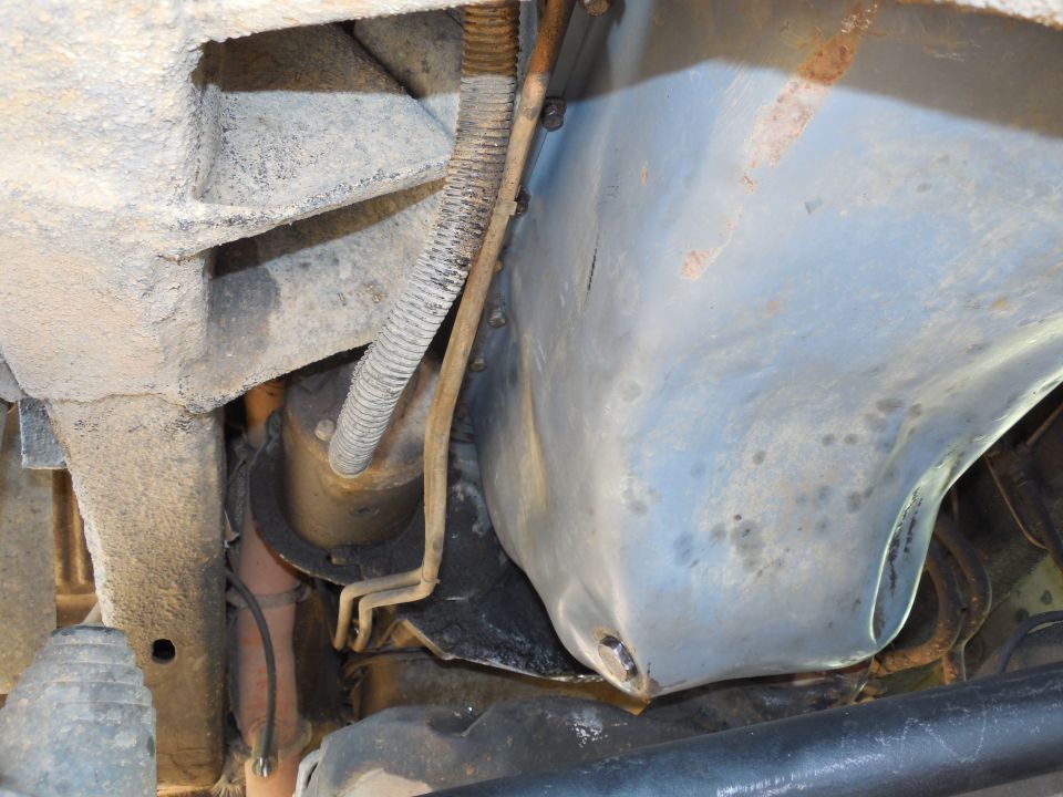 underbody view showing frame, exhaust pipe, and a metal shield