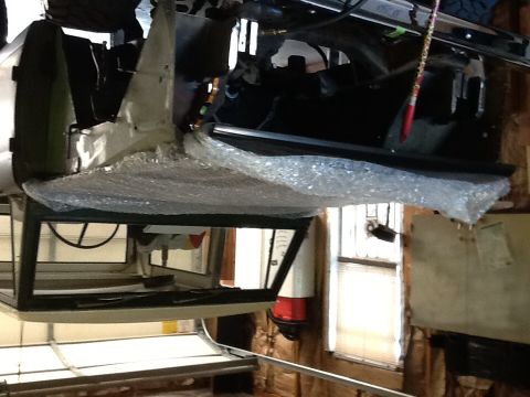 1988 Suzuki Samurai - The interior of a vehicle is seen from below, covered in bubble wrap, suggesting it is undergoing repairs or modifications.