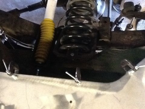 1988 Suzuki Samurai - Suspension component, likely a shock absorber and spring, viewed from below.