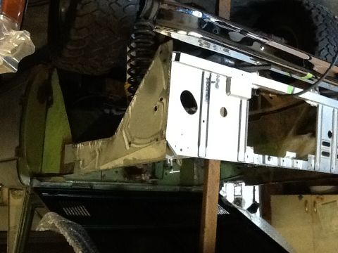 1988 Suzuki Samurai - Close-up view of a vehicle's frame and suspension components, showing exposed metal and some green bodywork.
