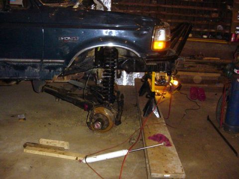 1992 Ford Bronco - Front suspension of a 1992 Ford Bronco is disassembled for repair in a garage.