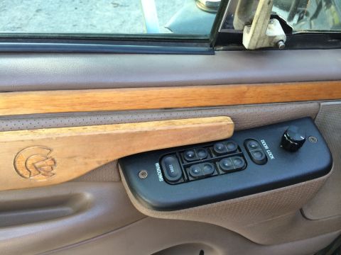1997 Ford F-350 - Interior door panel of a 1997 Ford F-350 features wood trim and power window controls.