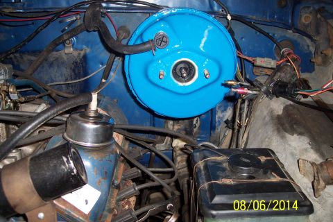 1978 Ford Bronco - Close-up view of engine bay components, including a blue brake booster and various hoses and wires.
