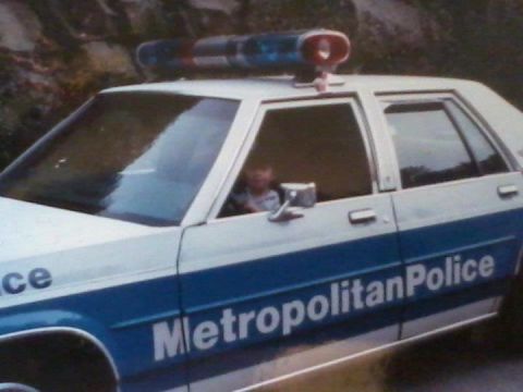 1991 Ford LTD Crown Victoria - A police car with "Metropolitan Police" written on its side is seen from the side, a light bar on the roof.