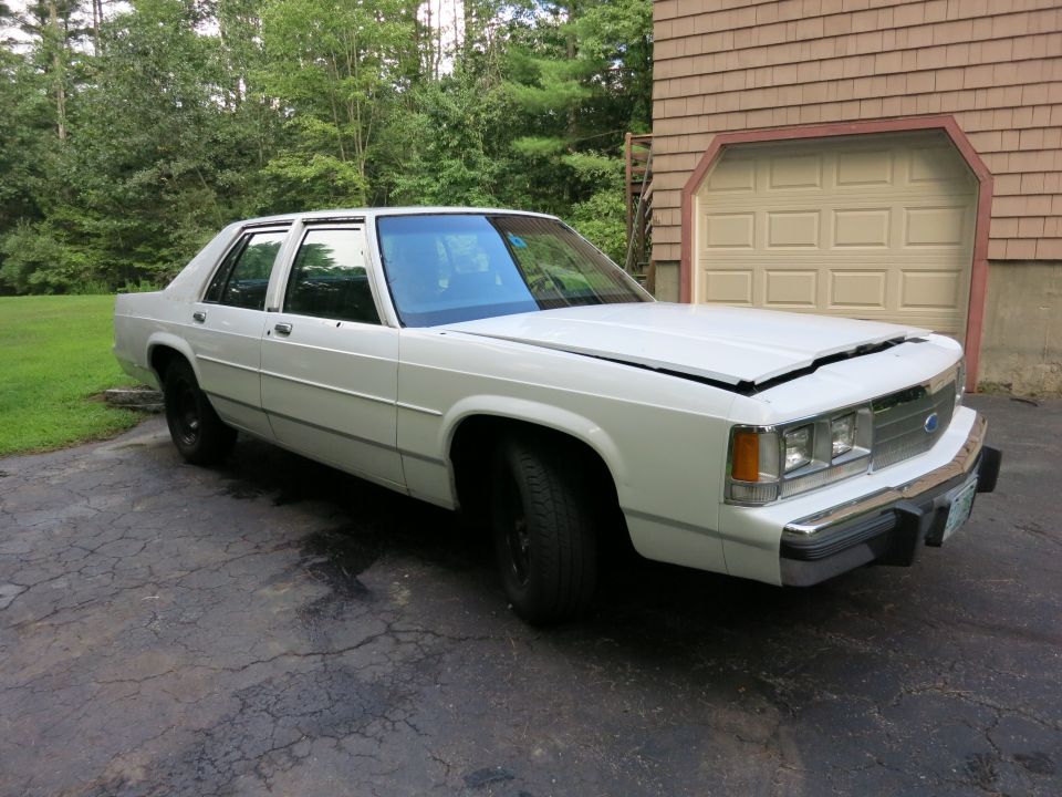 White 1991 Ford Crown Victoria parked in front of a garage