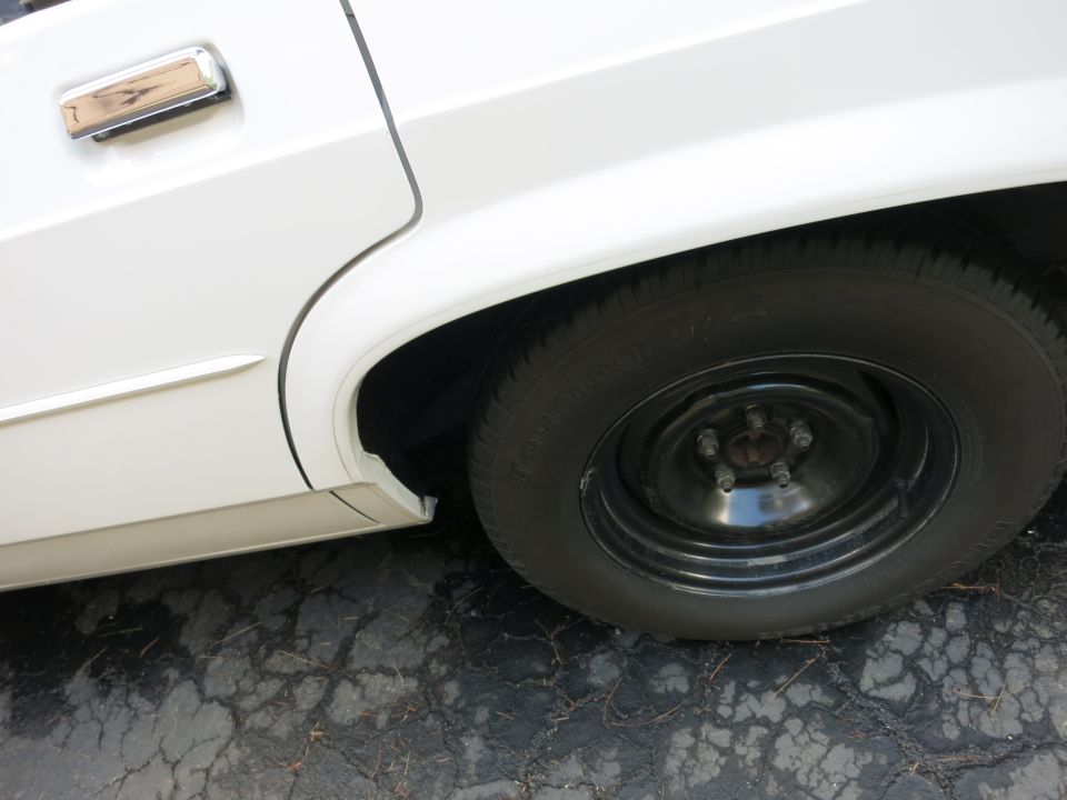 1991 Ford Crown Victoria LTD rear wheel and chrome door handle on white body