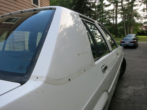 1991 Ford LTD Crown Victoria - Side view of a white 1991 Ford Crown Victoria LTD, with a second vehicle visible in the distance.