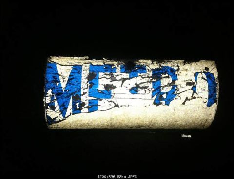 1991 Ford LTD Crown Victoria - A damaged decal with blue text is visible on a curved surface against a dark background.