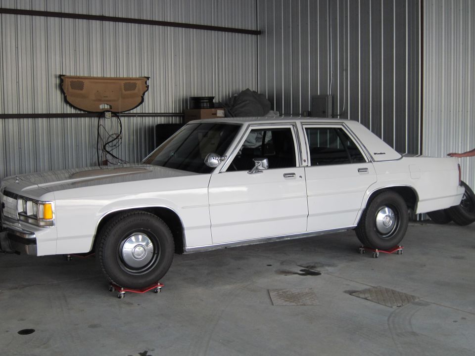 1991 Ford Crown Victoria LTD parked on red dollies in a garage