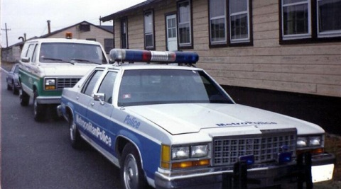 1991 Ford LTD Crown Victoria - A 1991 Ford Crown Victoria LTD police car is parked behind a van, with 'Metropolitan Police' visible on its side.