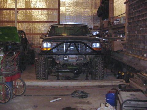 1992 Ford Bronco - Front view of a 1992 Ford Bronco parked in a garage with a custom bumper.
