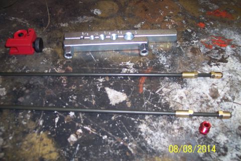1978 Ford Bronco - A brake line flaring tool and two brake lines are laid out on a workbench, along with a red tubing cutter.