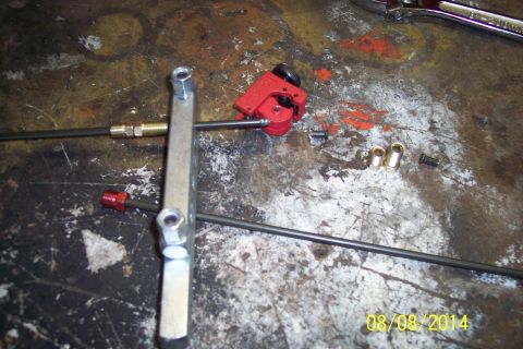 1978 Ford Bronco - Tools and parts are laid out on a workbench, likely for automotive brake line maintenance.