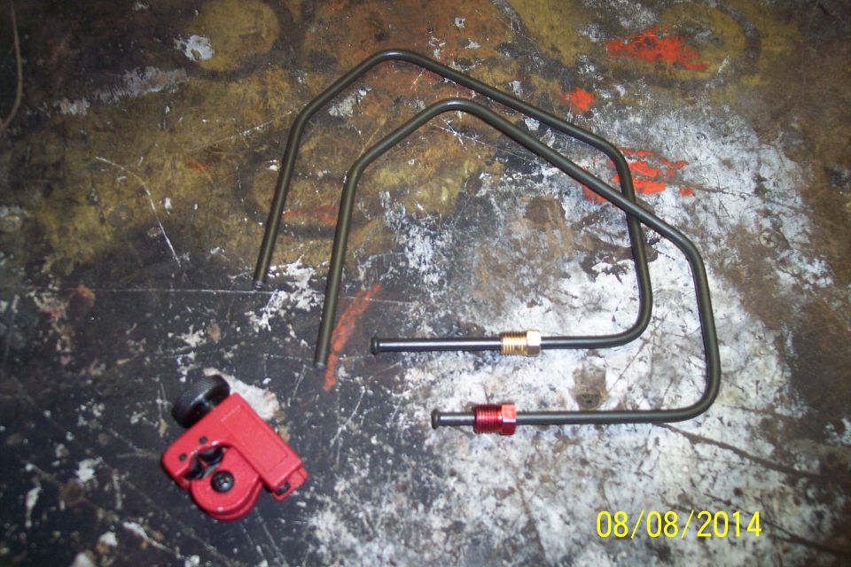 Tubing cutter and bent metal brake lines on a workbench