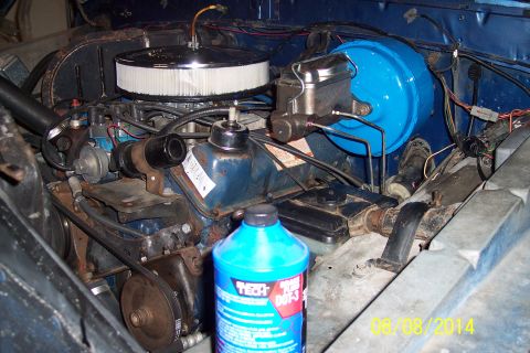1978 Ford Bronco - Engine bay components including brake booster and master cylinder, with a bottle of brake fluid in the foreground.