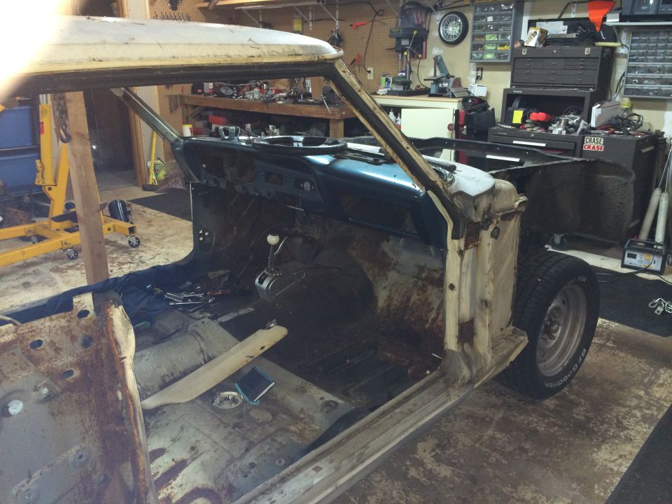 1964 Ford Fairlane interior and side, heavily rusted, in a garage with tools