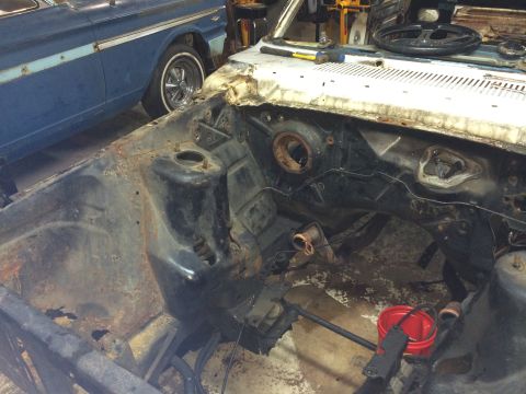 1964 Ford Fairlane - The engine bay of a disassembled 1964 Ford Fairlane shows significant rust and missing components.