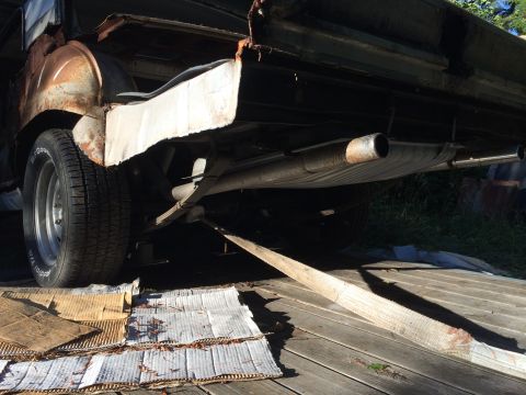 1964 Ford Fairlane - The rear underside of a 1964 Ford Fairlane shows significant rust and damage, with dual exhaust pipes visible.
