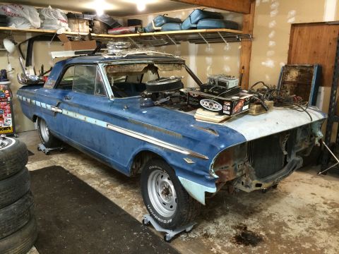 1964 Ford Fairlane - Project 1964 Ford Fairlane sits in a garage with its front end removed and parts piled on the hood.