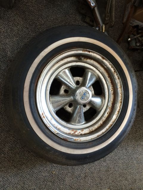1964 Ford Fairlane - A close-up view of a single chrome wheel and tire assembly, showing some rust on the rim.