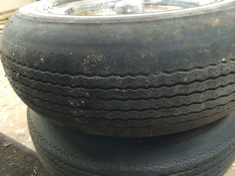 1964 Ford Fairlane - A close-up view of two stacked tires, showing their tread patterns and a chrome rim on the upper tire.