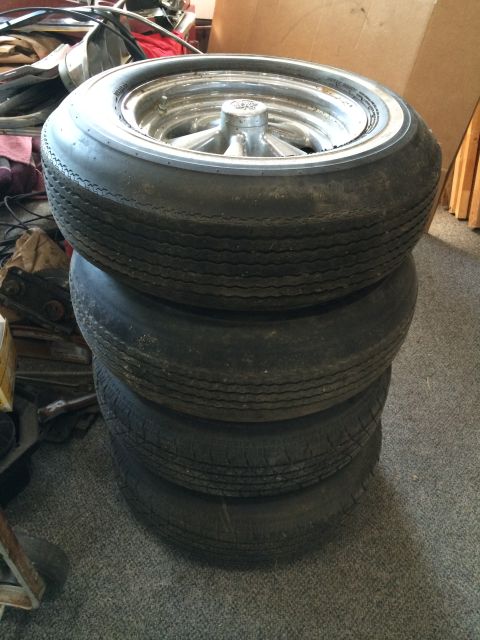 1964 Ford Fairlane - A stack of four tires and rims are shown, with the top tire a white sidewall.