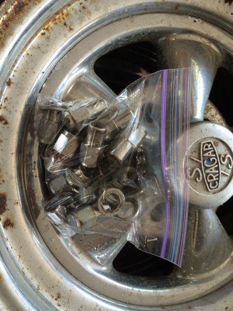 1964 Ford Fairlane - A Cragar S/S wheel is shown with a bag of lug nuts inside. The wheel shows signs of rust.