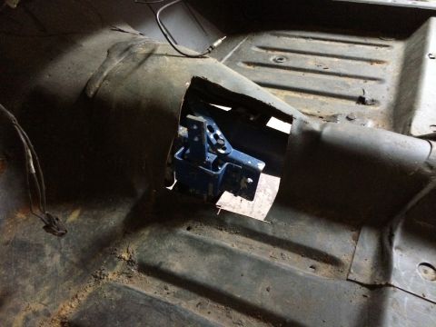 1964 Ford Fairlane - Interior floor pan of a car with a cut-out revealing a blue mechanism below.