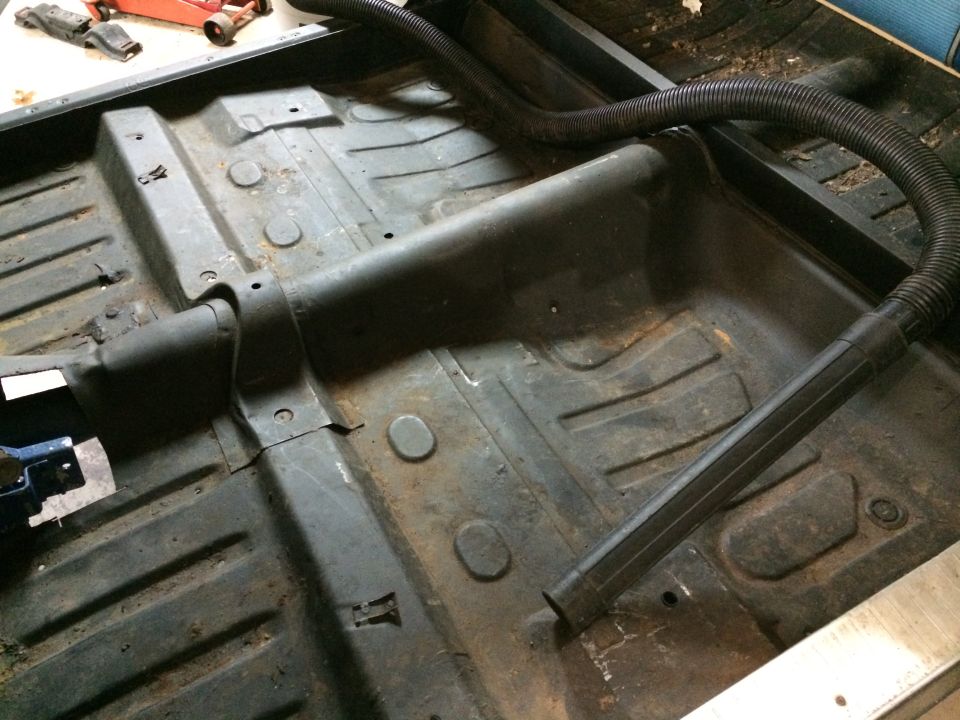 1964 Ford Fairlane interior floor pan, gray, with vacuum hose and visible rust
