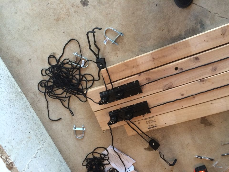 wood planks, ropes, pulleys, and hardware on concrete floor