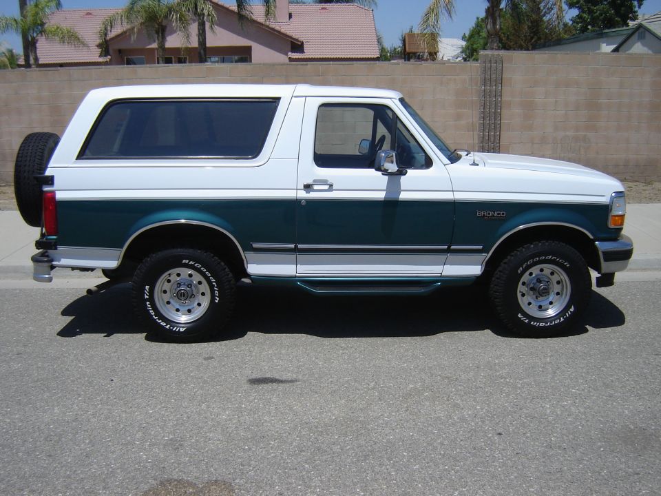 Two-tone green and white Ford Bronco with a spare tire on the back