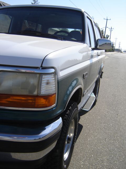 1996 Ford Bronco - This 1996 Ford Bronco is shown from the front passenger side, parked on a street with utility poles in the background.