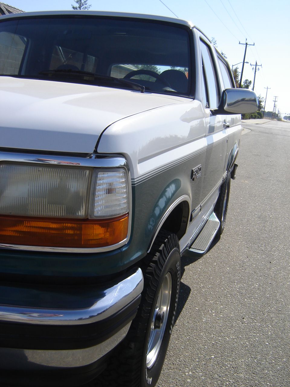 Front quarter view of a white and green 1996 Ford Bronco parked on a street