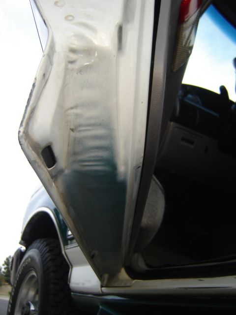 1996 Ford Bronco - Close-up view of the door jamb on a 1996 Ford Bronco, revealing its two-tone paint scheme.