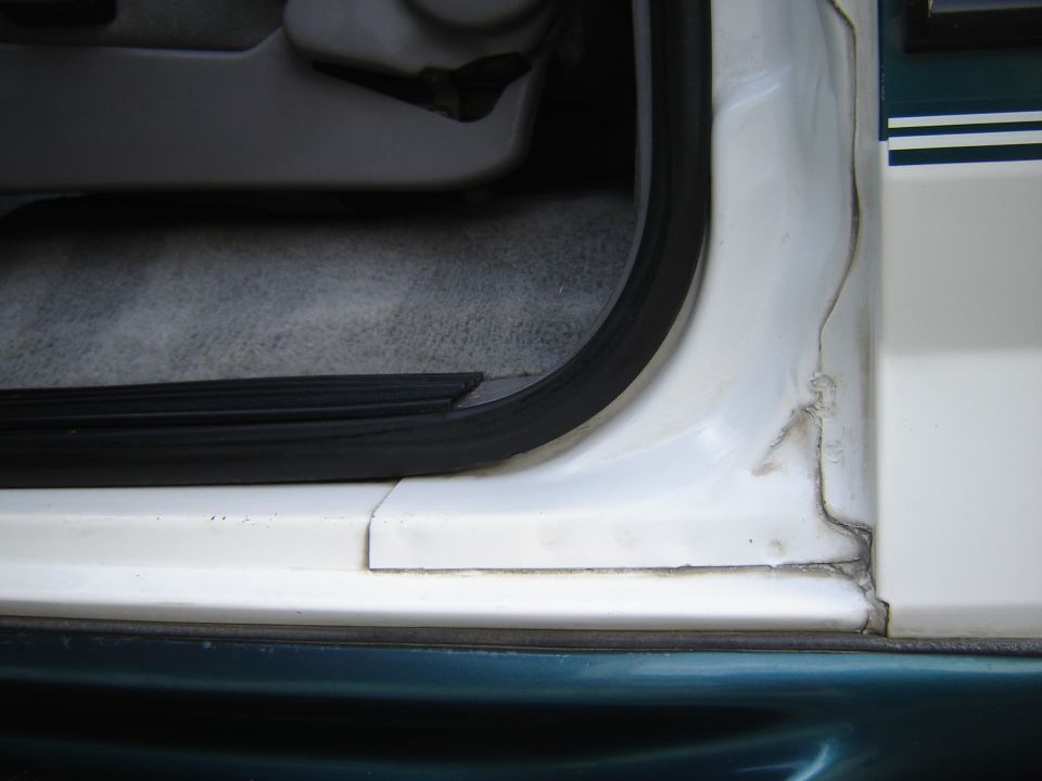 Close-up of a car's interior door frame and carpeted floor