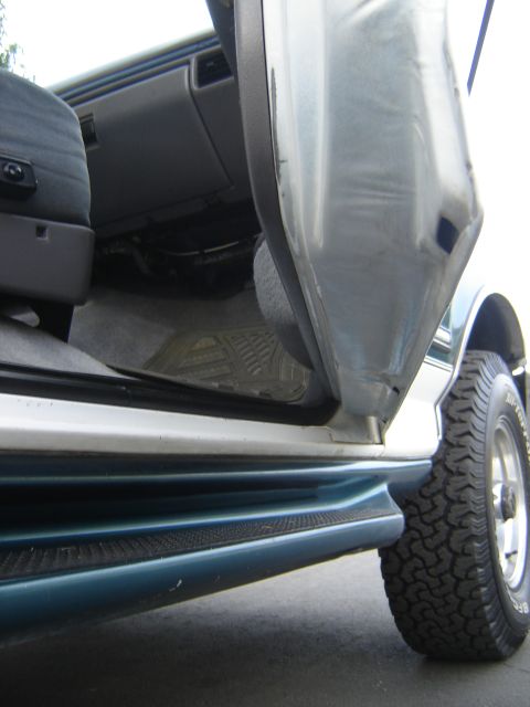 1996 Ford Bronco - View of the interior and exterior side panel of a vehicle with the door open.