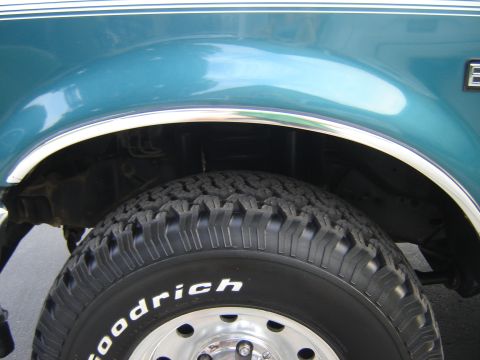 1996 Ford Bronco - A teal 1996 Ford Bronco's side profile, showing the fender, wheel well, and tire.
