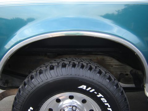 1996 Ford Bronco - Close-up of the rear wheel well and tire on a 1996 Ford Bronco, showing the "All-Terrain" tire branding.