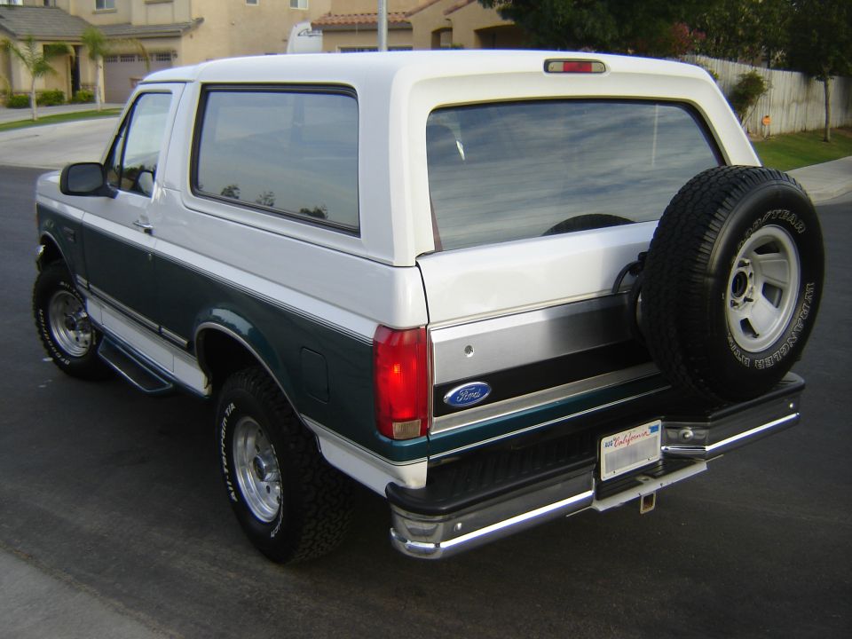 Two-tone green and white 1996 Ford Bronco with a spare tire mounted on the rear door
